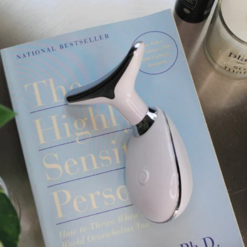 top view of a white face massager on a book.