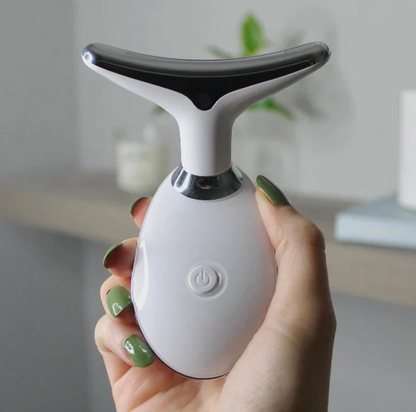woman's hand holding a white pure aura face massager.